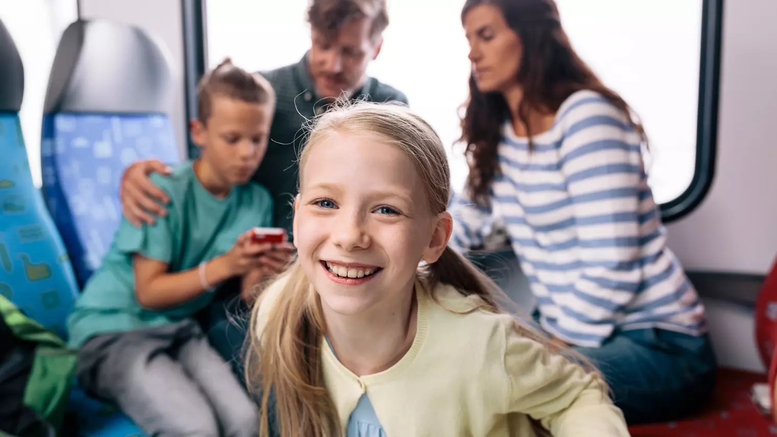 Eine Familie sitzt auf den Sitzen der S-Bahn